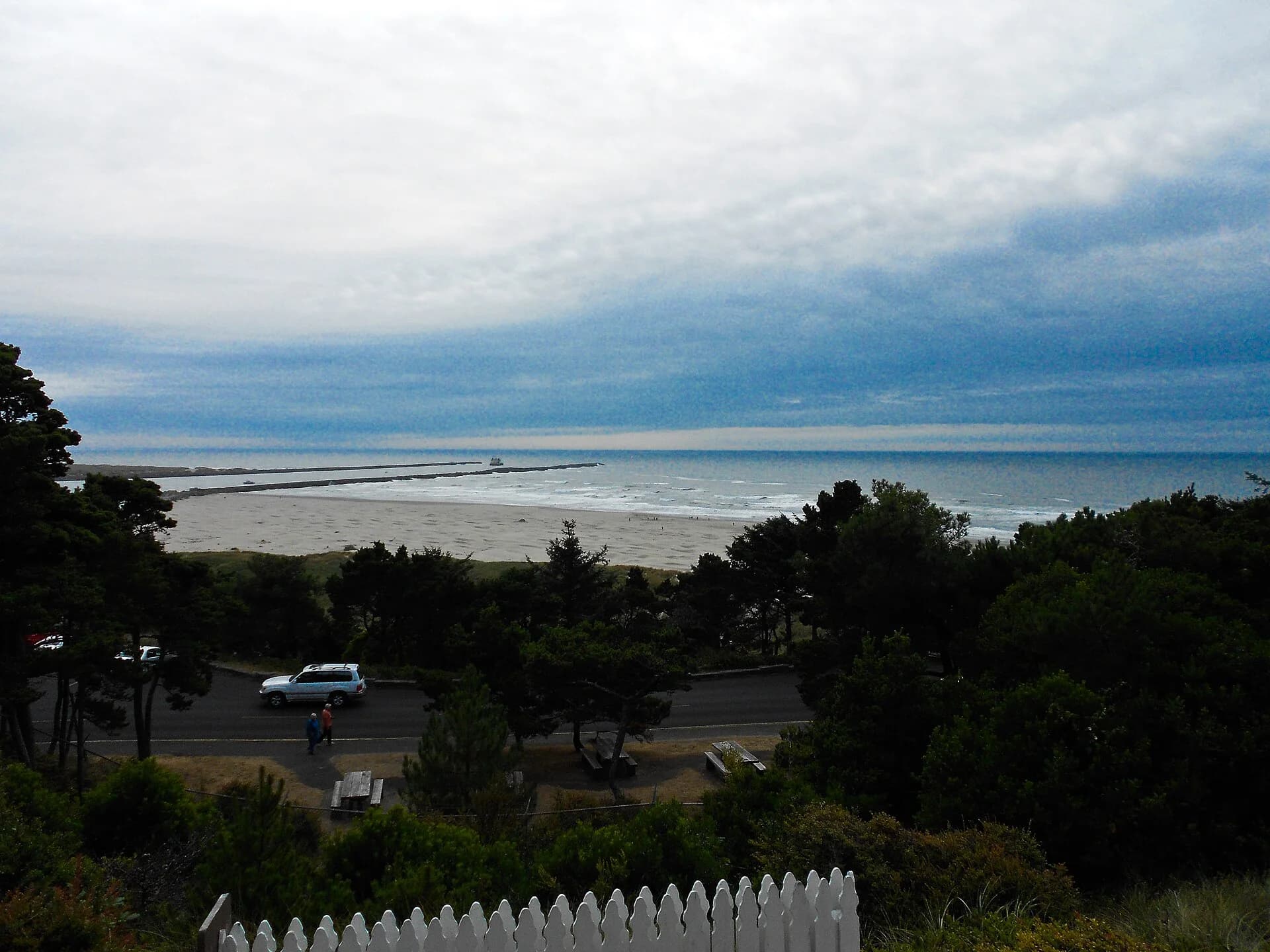 View over trees and a parking area toward the bay entrance and ocean.